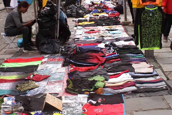 5. "Camelôs" selling imitations of Nike and Adidas clothing in the sidewalk of a commercial street full of "formal" stores. Rio de Janeiro, Brazil, 2022.